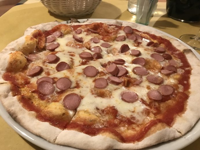 picture of a pizza with hot dogs on it.
